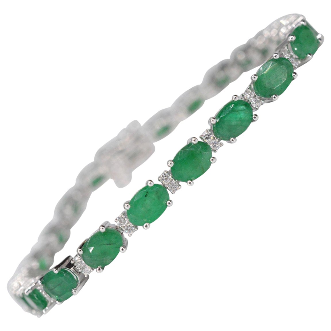 This elegant bracelet features a striking combination of diamonds and emeralds, offering a sophisticated and timeless look. The diamonds weigh a total of 0.50 carats, cut in a brilliant style, with a color grade of F-G and clarity of SI-P. The