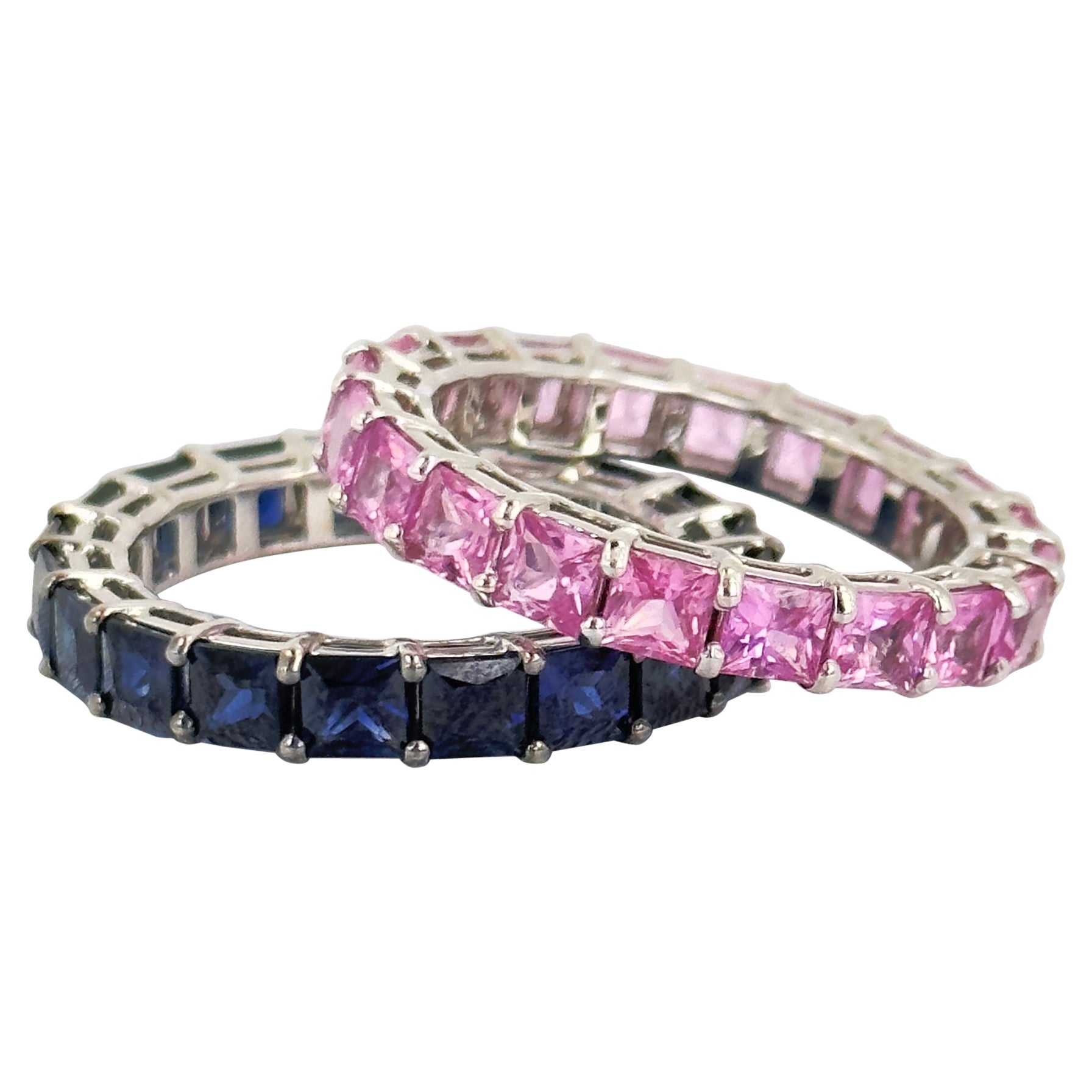 Princess cuts on a princess! Our new blue sapphire and pink sapphire eternity bands are here for you and your princess! Shared prong with a basket design, each princess cut sapphire is held securely so you can flash the ring in public! The pink