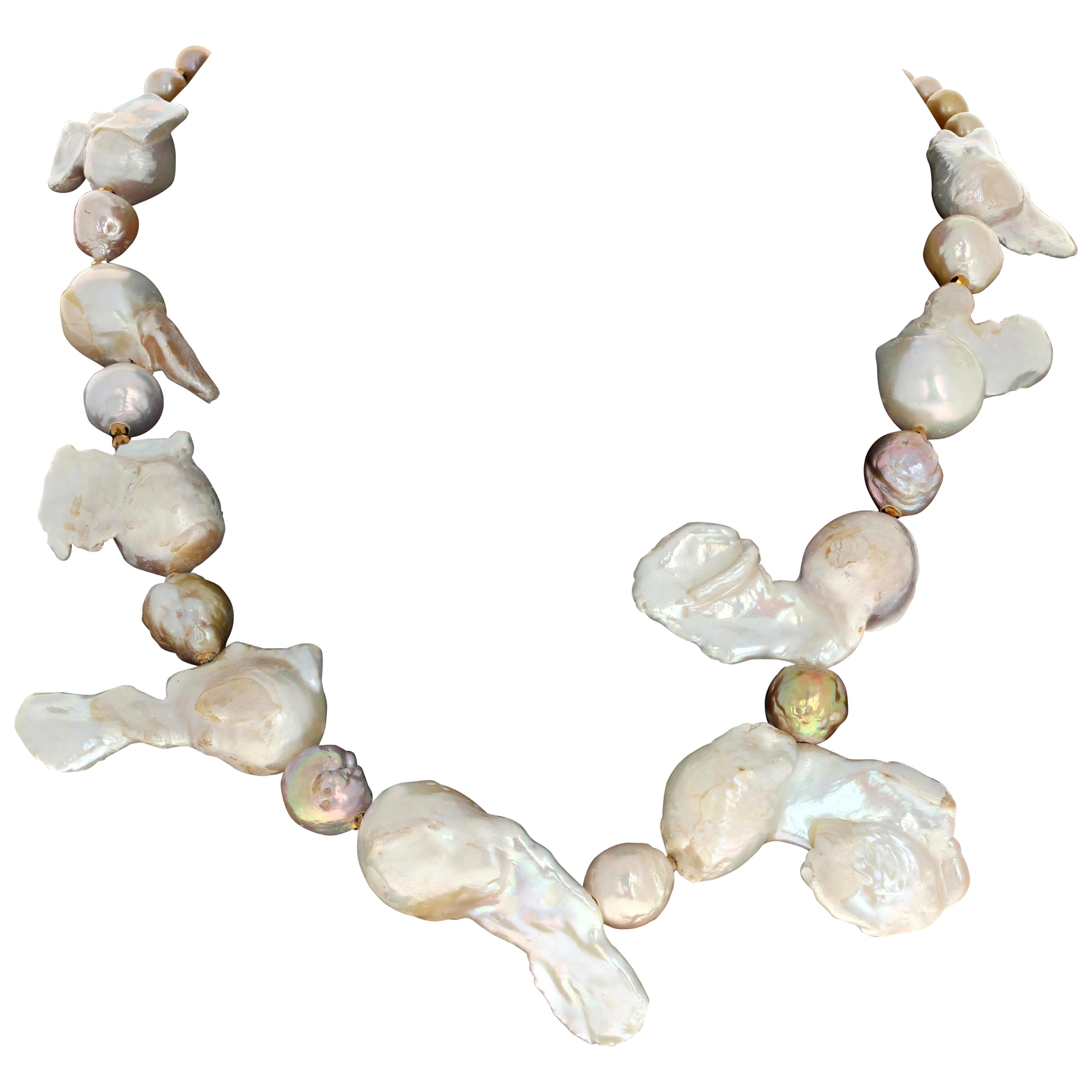 This fascinating necklace is 18 1/2 inches long.  The Pearls are natural just the way they grew so oddly dramatic in their natural shells.  The round parts are approximately 18mm ant they are about 40mm long.  The smaller little Pearls are