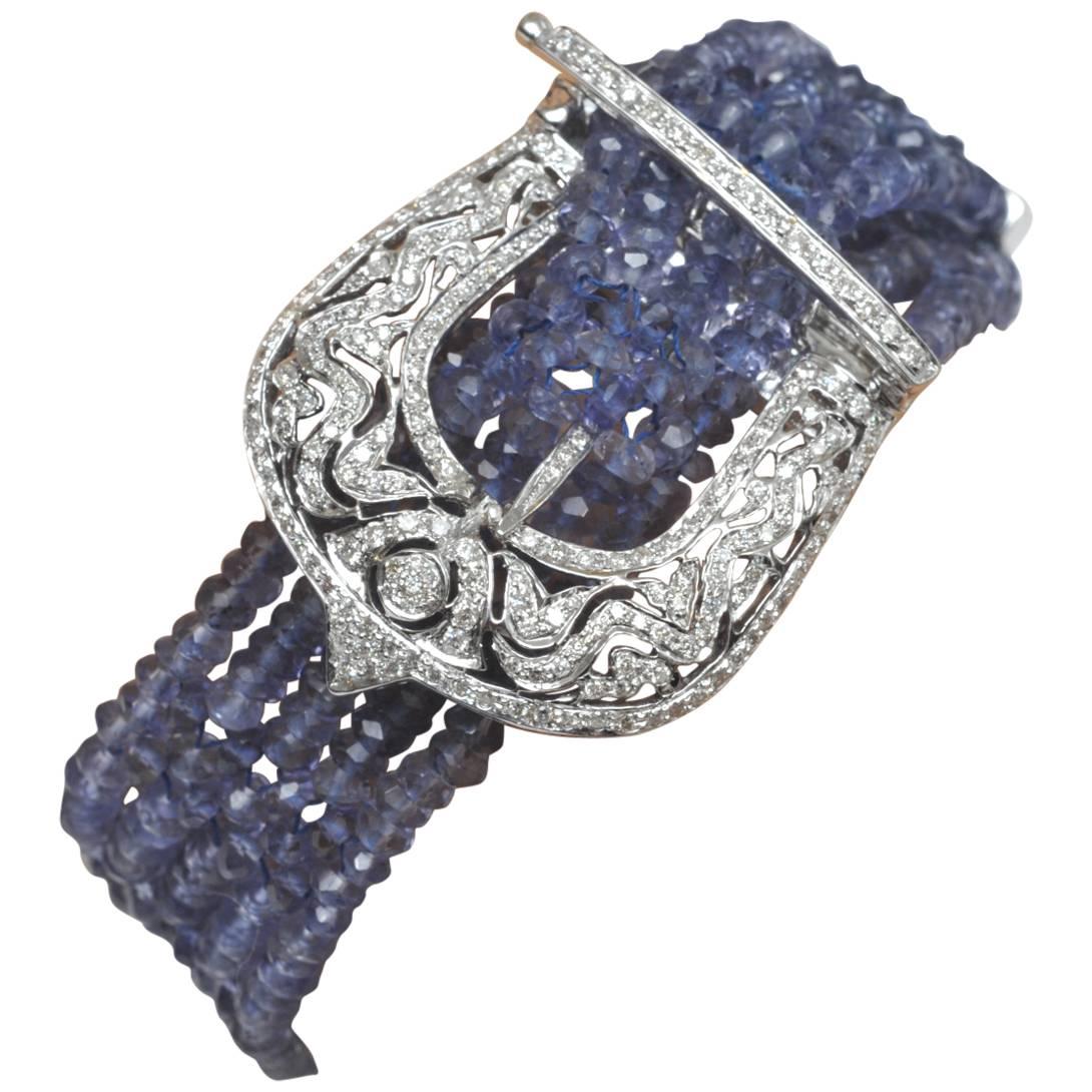 A fabulous five-strand buckle bracelet of faceted tanzanite gemstones with pave`-set diamonds on the buckle frame portion, and along the top of the bar clasp which weaves its way through the stones with prongs that snap into place.  Diamonds also