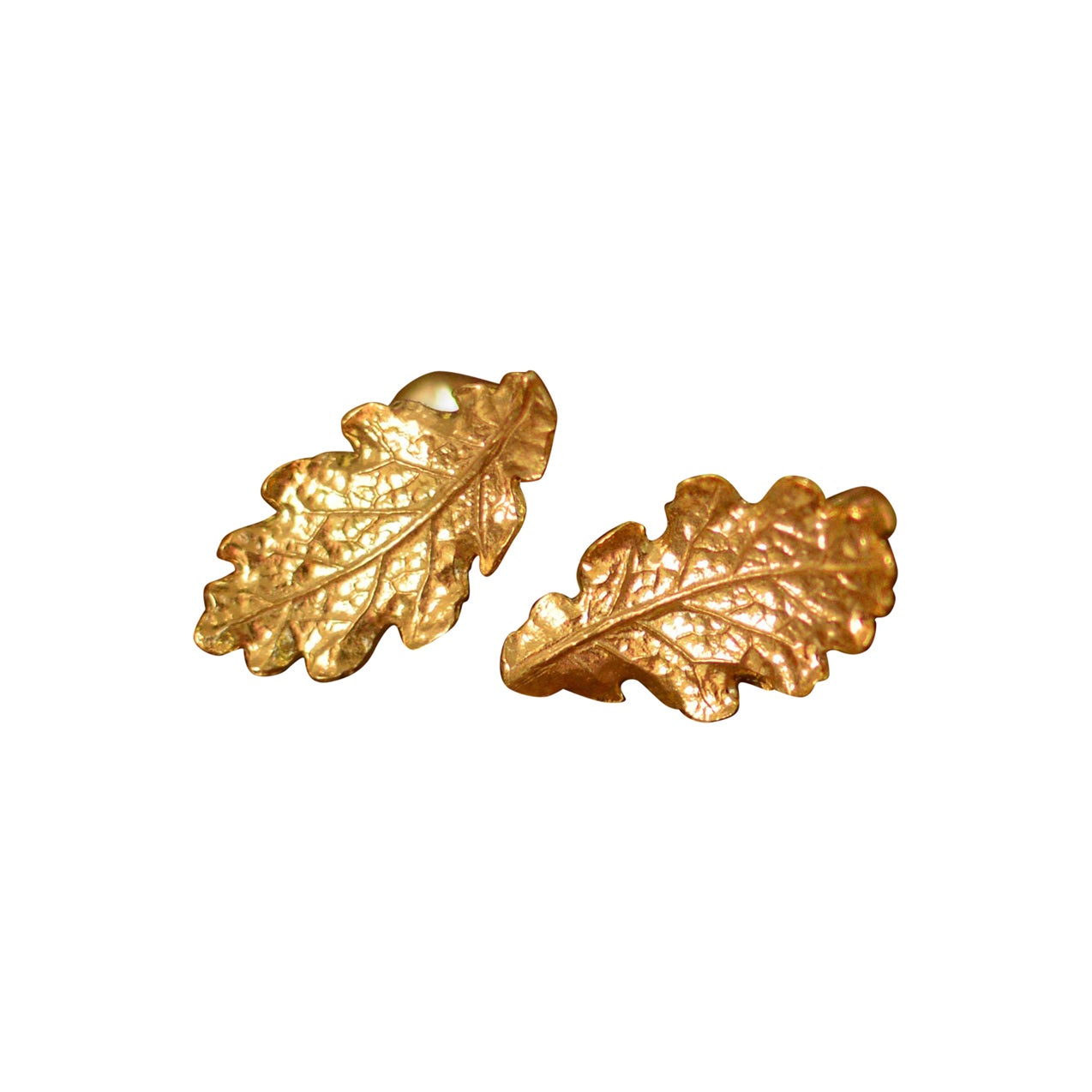 These curling oak leaves form a half-hoop shaped stud earrings are cast in solid 18 Carat gold and finished by hand, and created from Lucy's original hand-sculpted design. 

These oak leaf earrings are made in London, United Kingdom using recycled