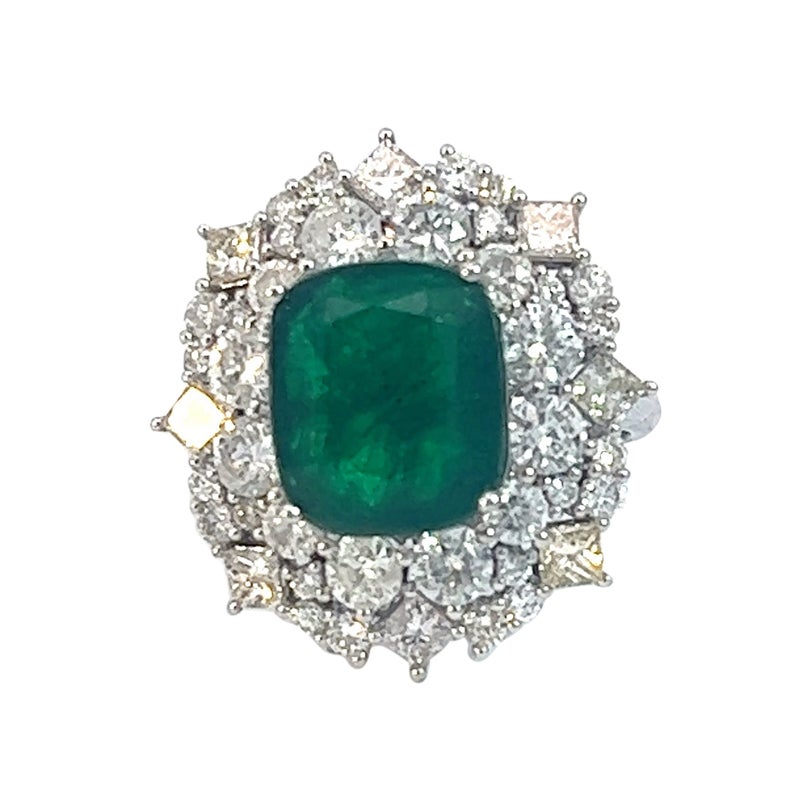 This stunning natural emerald and diamond ring is a true masterpiece that exudes luxury and elegance. The centerpiece of the ring is a breathtaking 6.05 carat cushion-cut natural emerald that boasts a deep green hue that's simply mesmerizing.