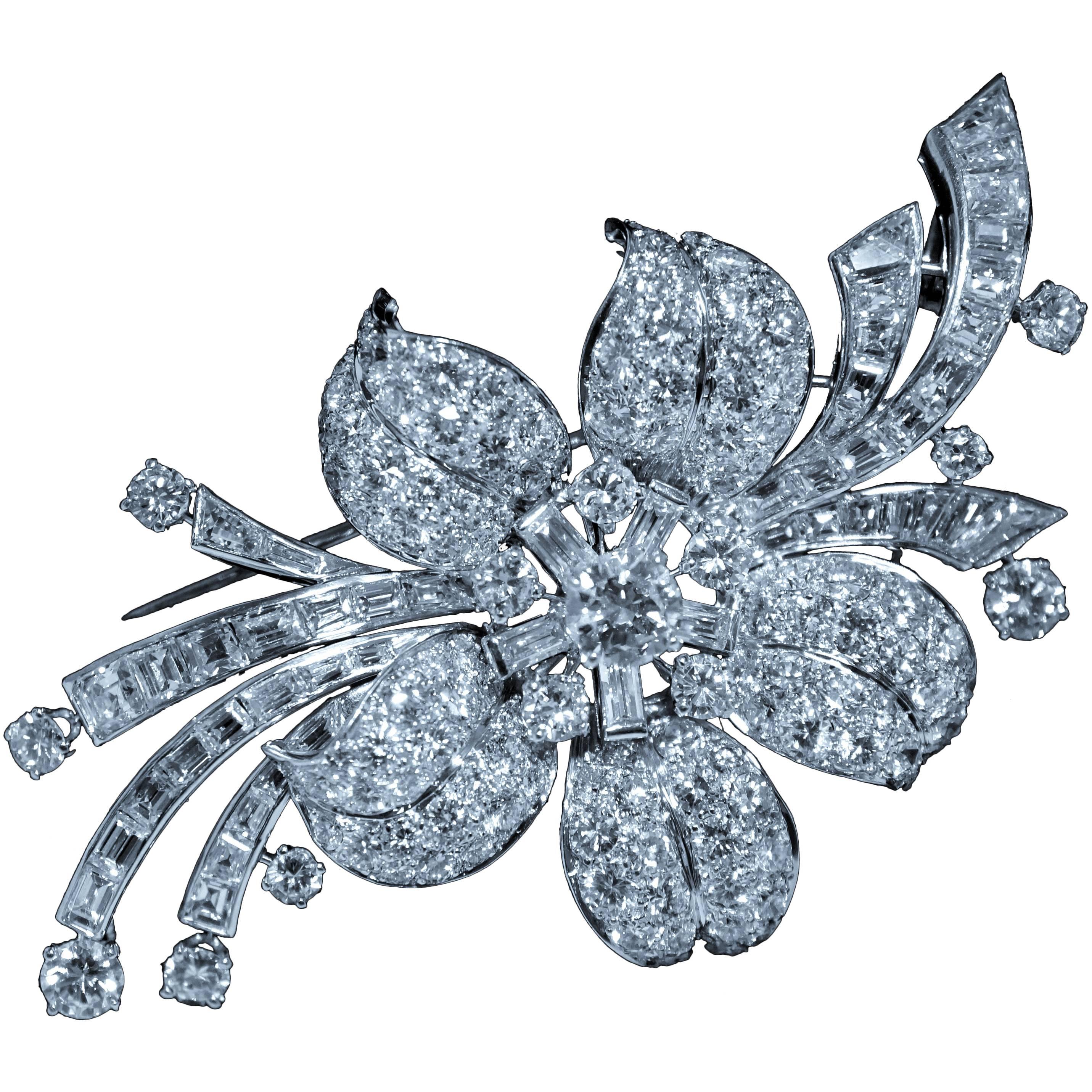 This is a signed Van Cleef & Arpels platinum diamond pin. It contains channel set  and tapering baguette diamonds, pave set  and prongset  round modern brilliant cut diamonds. Fine white and VS clarity diamonds set in a extraordinary flower