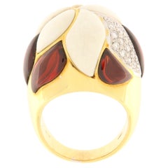 Kuppelförmiger Ring aus Gelbgold mit Brillanten, weißer Koralle und Cabochon-Granaten