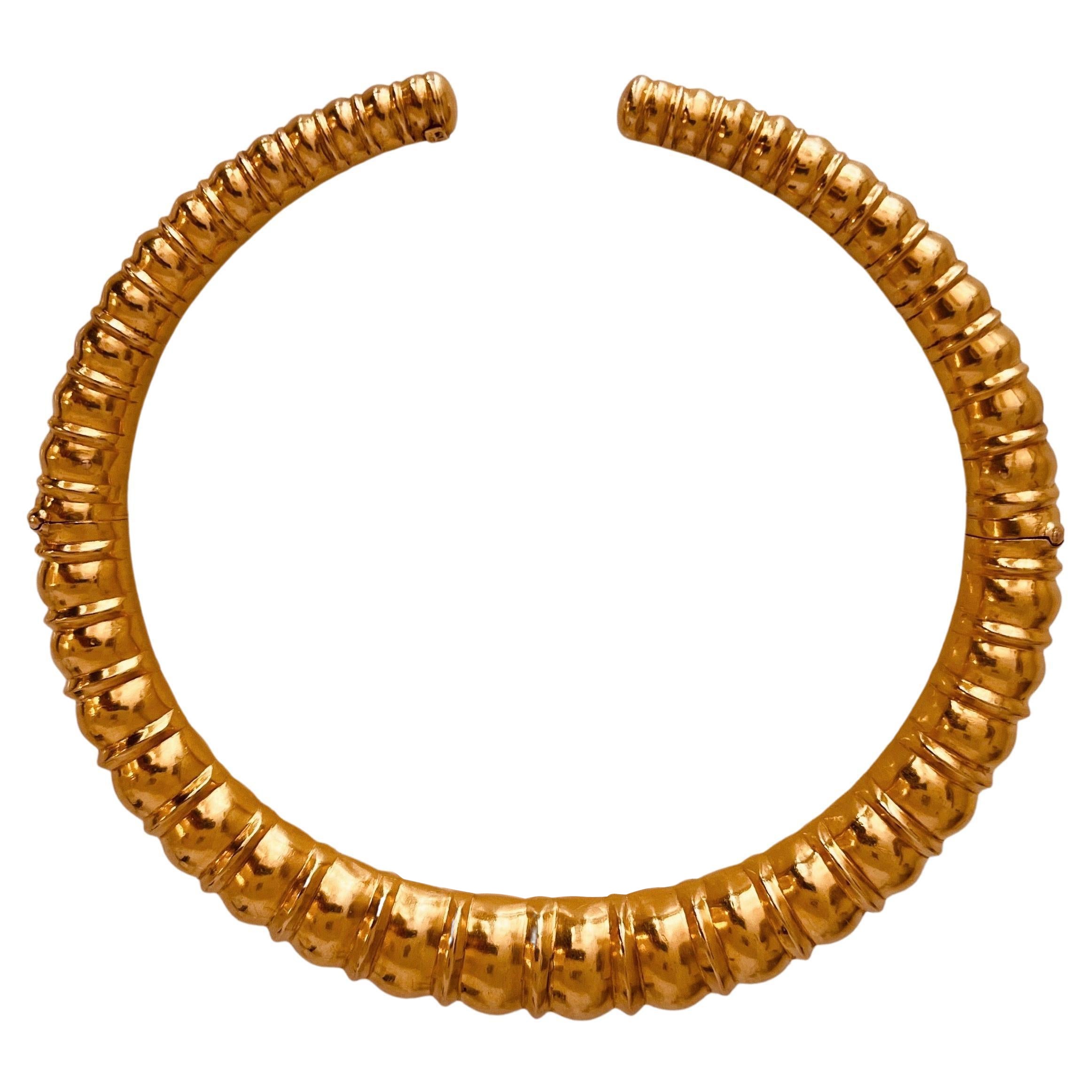 A high carat gold torque of graduated rounded rib design inspired from the Mycenaean period. 20-22 carat gold choker necklace. 34 cm internal circumference. Weight: 102.2grams. Circa 1970's. Hallmarks: makers mark and signed. Price: 15,750£. Item is