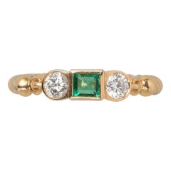 Ein dreisteiniger Cartier-Ring aus 18 Karat Gold mit Diamant und Smaragd