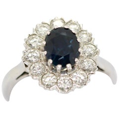 14 Karat Weißgold Ring mit einem großen Saphir und 12 weißen Diamanten besetzt.