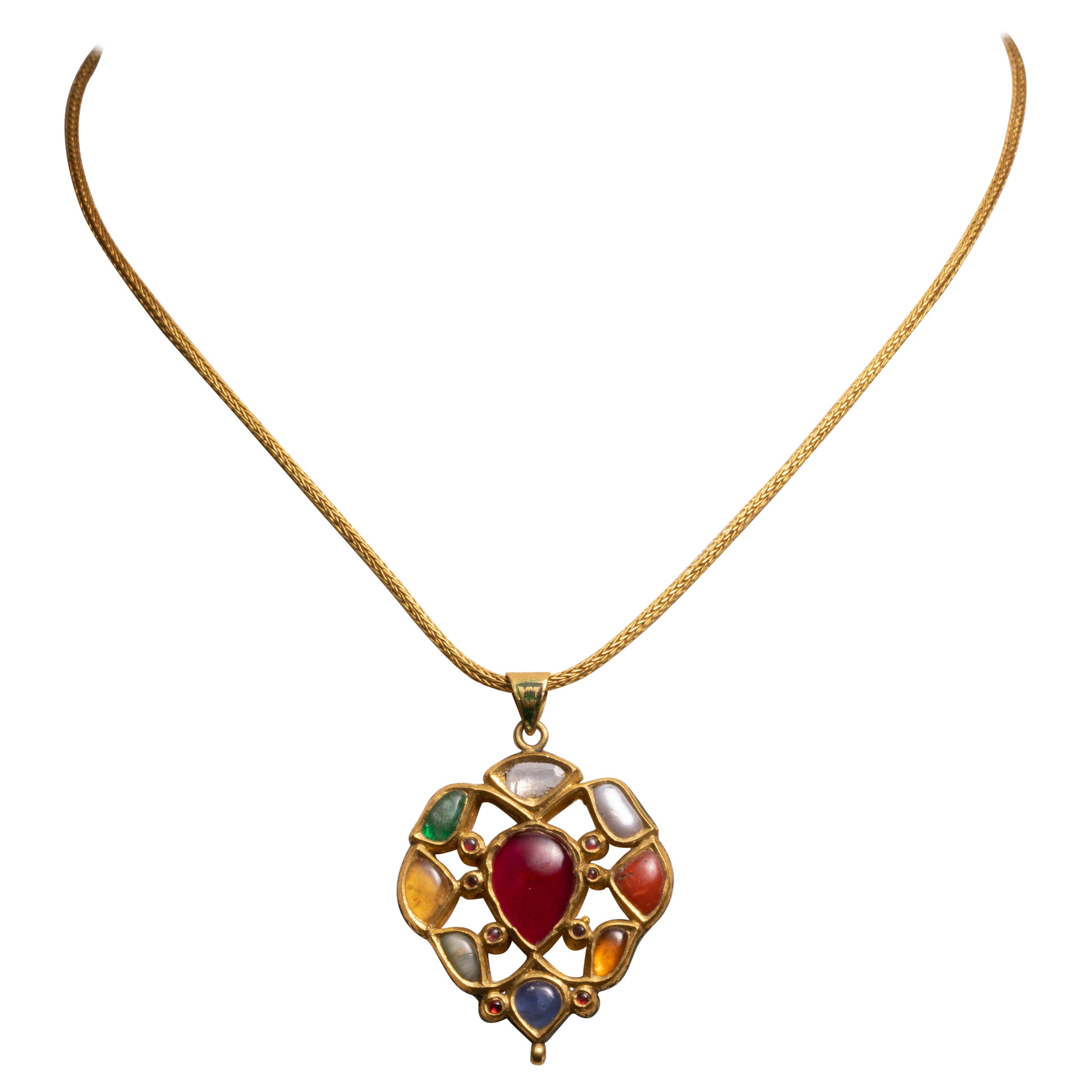 A 22K gold pendant with precious and semi-precious gemstones depicting the Nava Ratna mythology on one side and kundan gold and enamel work depicting flowers on the reverse. The pendant hangs from a hand-rolled 22K gold chain which has a screw-off