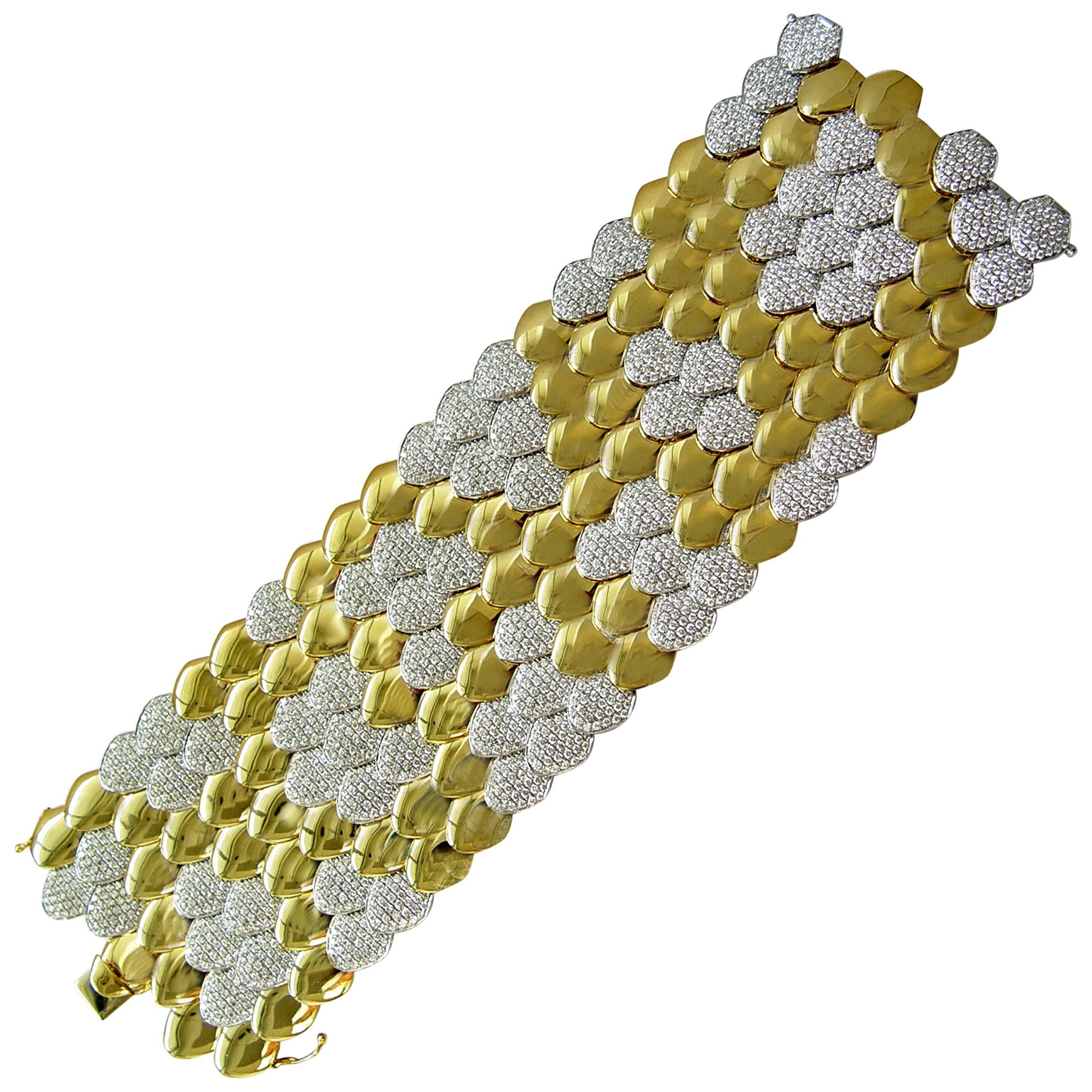 This magnificent bracelet designed to resemble fish scales pattern. The overlapping links are flexible, that makes it very comfortable to wear. The bracelet is crafted in the finest 18K yellow and white gold. Some of the sections are set with round