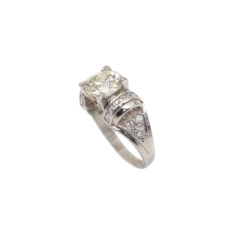 Magnificent Diamond Ring White Gold 18K. As stated in the certificate:
The weight of the center Diamond is 1.8 Carats. Old-cut.
Surrounded by the Baguette Cut Diamonds, in a total of 12 stones, weighting approximately 0.95 Carats.  

Total carat