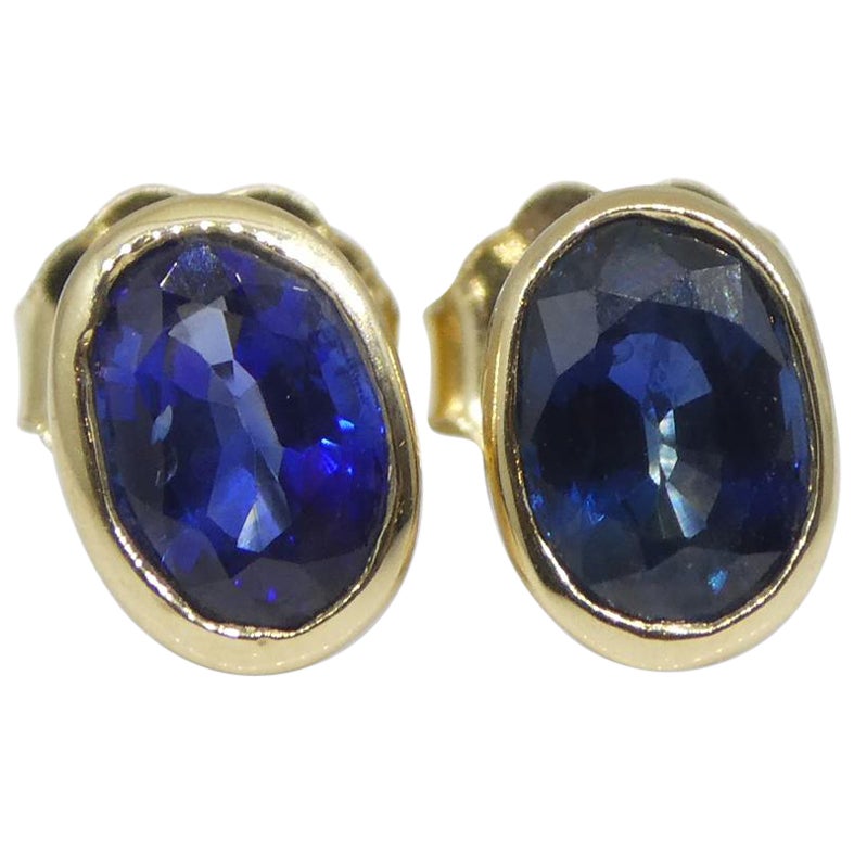 1.38ct Oval Blue Sapphire Stud Earrings set in 14k Yellow Gold For Sale