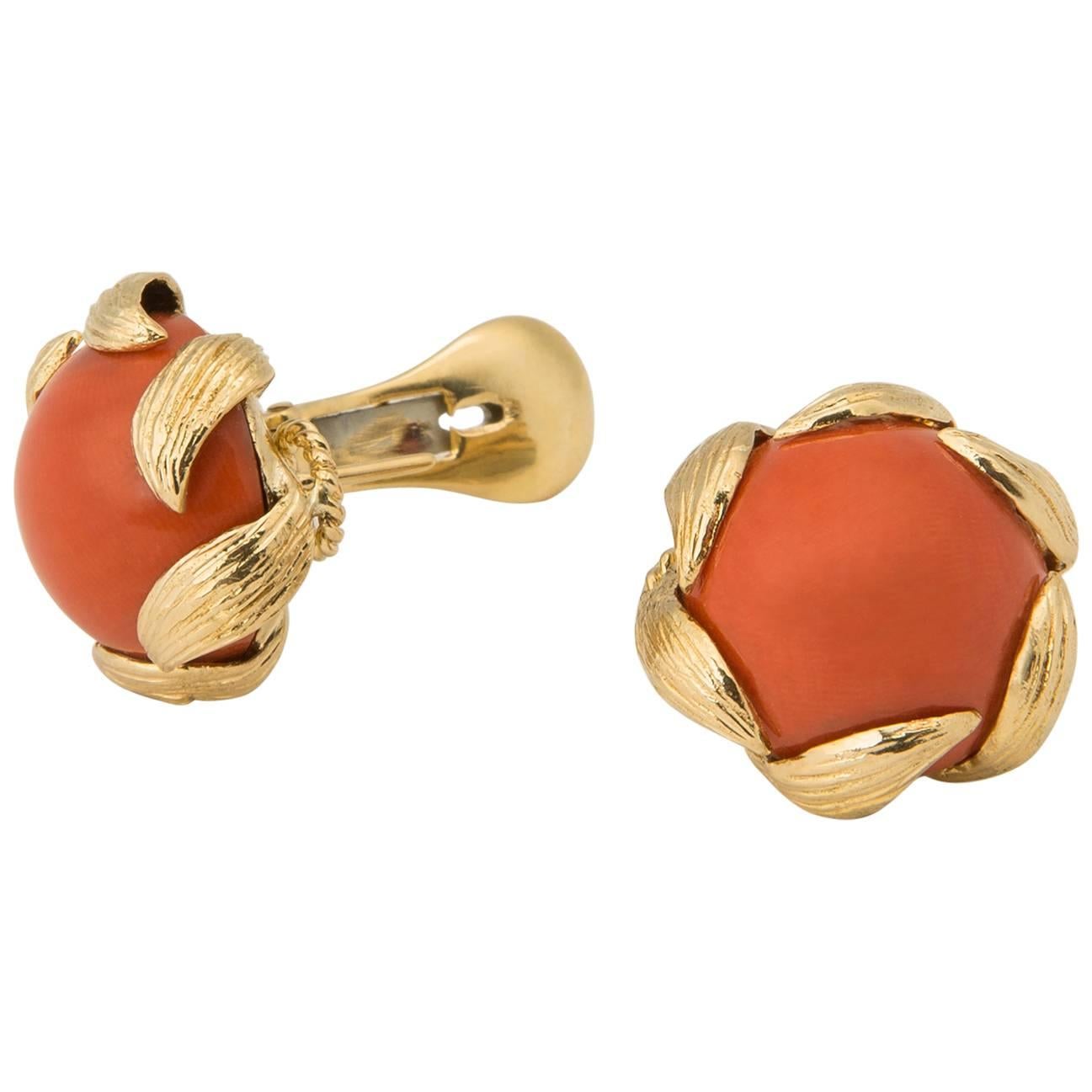 A wearable Iconic David Webb Creation. Deep rich orange coral is finished with elegant floral motif frames. An easy to wear 3/4 inch size. 