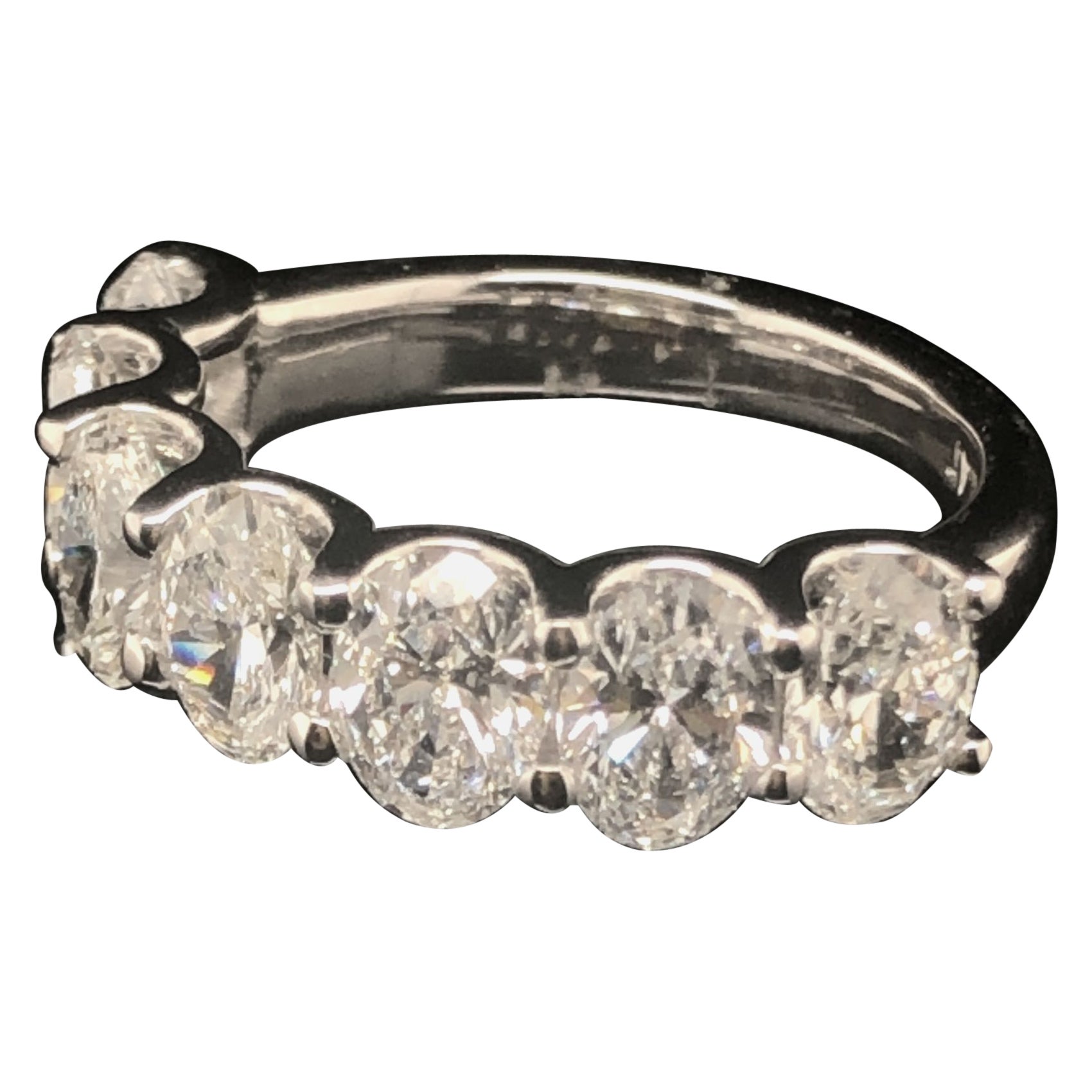 A half-way diamond band set with seven oval diamonds totaling 3.40 carats set in platinum is a stunning choice for a luxurious and elegant piece of jewelry. The combination of oval diamonds and platinum creates a timeless and sophisticated look that
