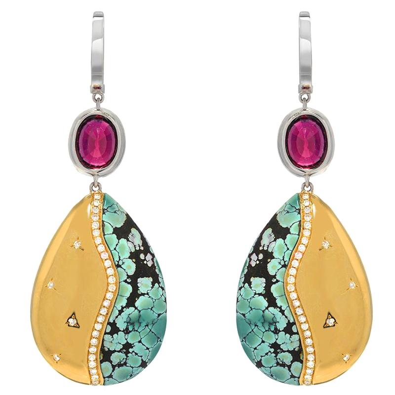 A truly special and unique pair of earrings. They are made with a frame of spiderweb matrixed turquoise, 43.90 carats, and 18K yellow gold. Two vivid red tourmaline at 4.87 carats are set atop the earrings in white gold. There is a total of 1.48