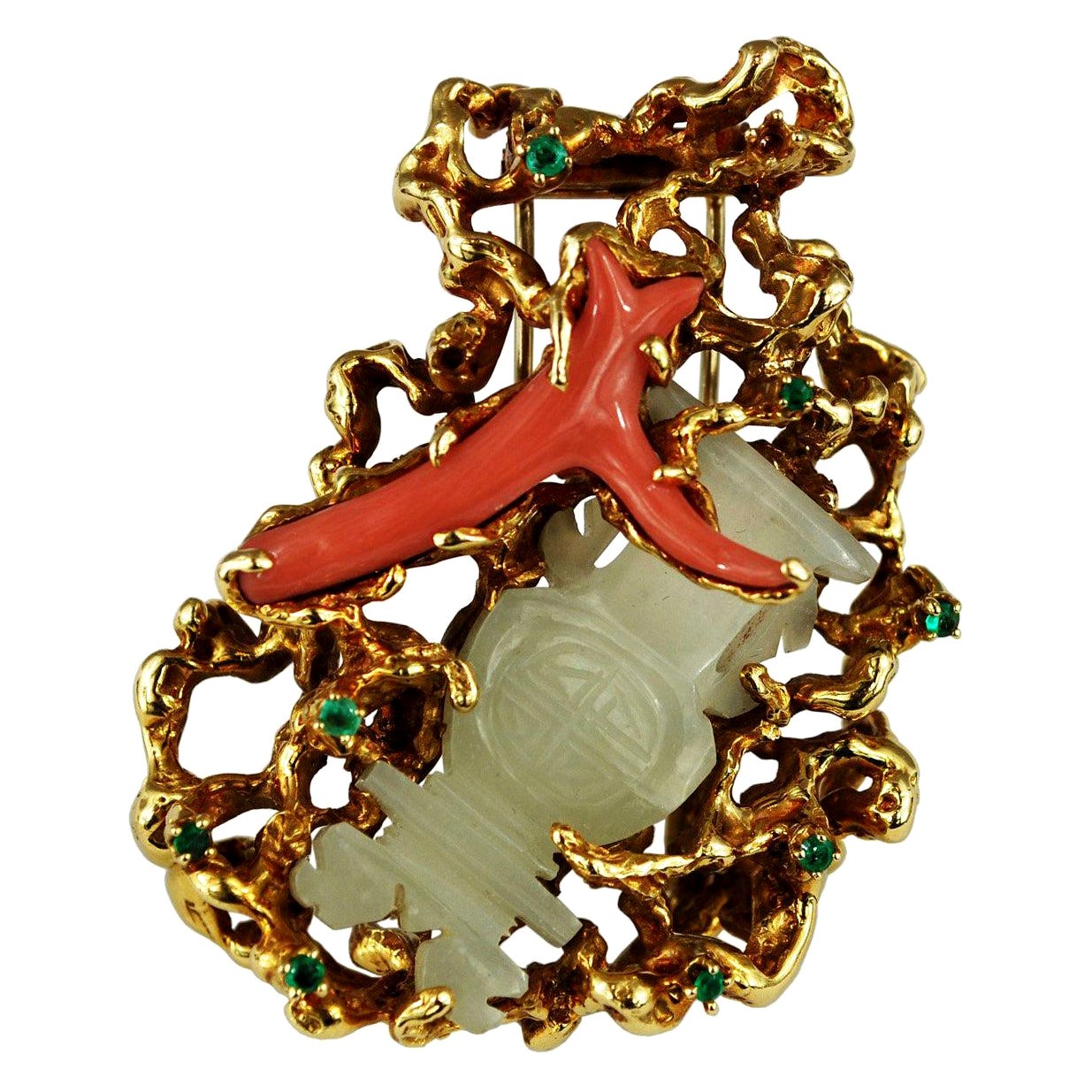 A large brooch by a famous jewelry designer Arthur King. The body of this unique freeform brooch is crafted out of 18K gold. Two centerpieces are clutched firmly in the base, one a whimsically shaped piece of coral, the other a pale jade piece