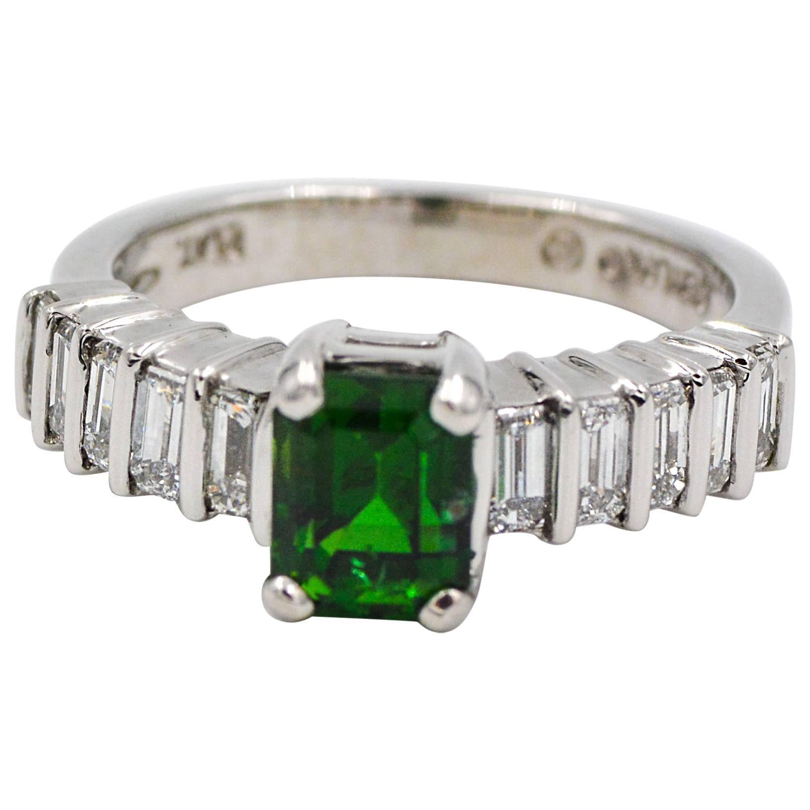 This beautiful platinum ring is centered by a vivid green emerald cut tourmaline.  The tourmaline is accented by ten baguette cut diamonds that are bar set length wise, five on each side of the beautiful tourmaline center stone.  The accent diamonds