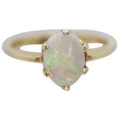 Anillo en garras con solitario de ópalo de 14 quilates. Banda solitaria de ópalo cristalino.