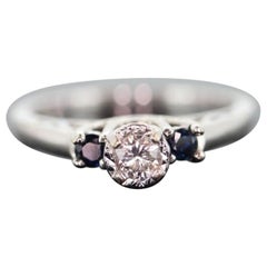 Anello con diamante e zaffiro. Solitario con diamante e zaffiro in oro bianco 14k. Trio Trilogy