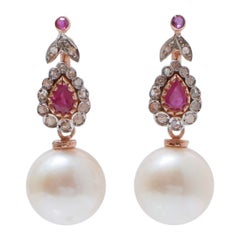Orecchini con perle bianche, rubini, diamanti, oro rosa e argento.