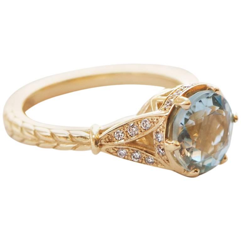 1.64 Carat Round Aquamarine stone set in our Vintage handmade 'Princess' setting in 18k Yellow Gold. 0.20 Carats of 1.3mm Diamonds compliments the romantic design of this setting.

Designer Douglas Elliott has always been inspired by Art Deco