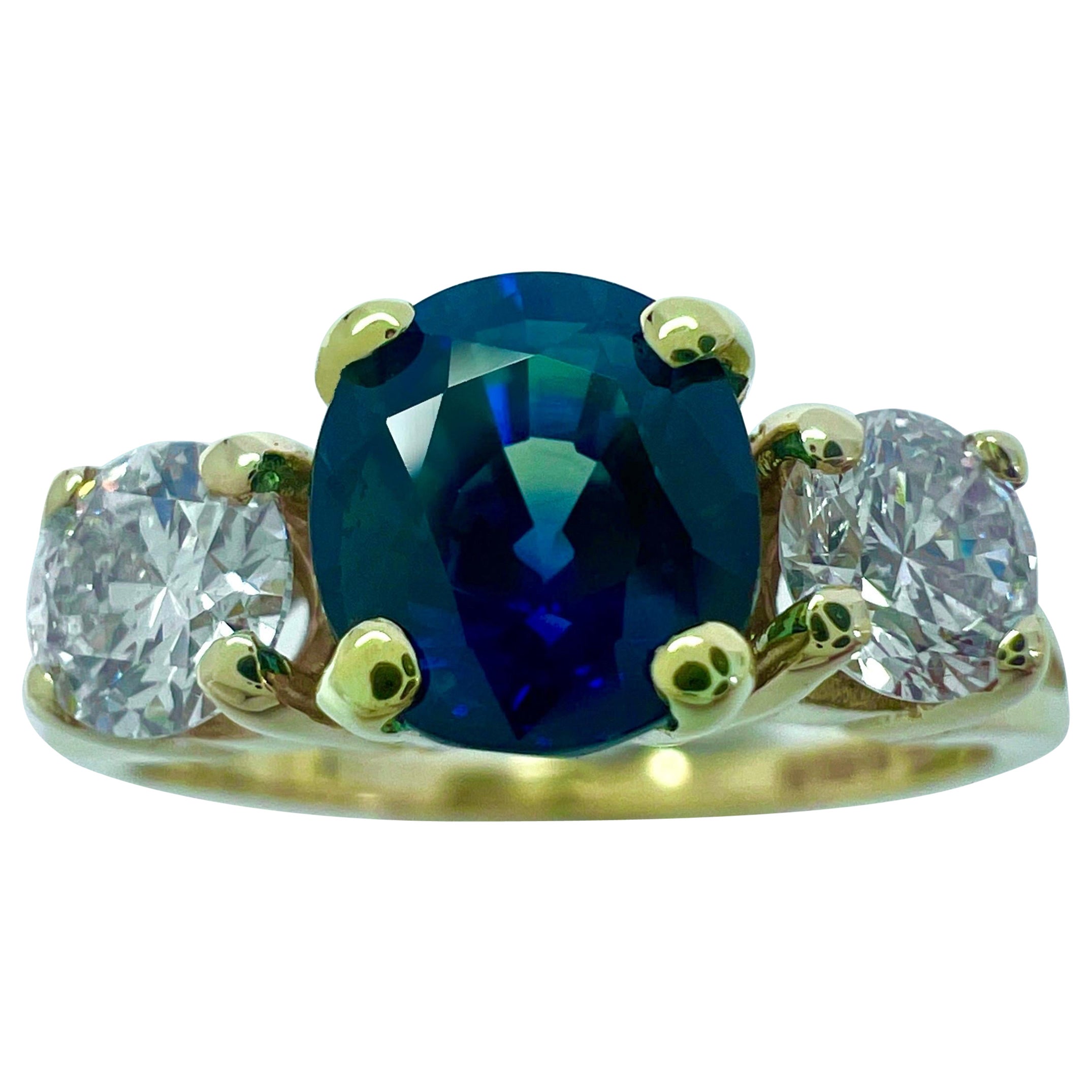 Anello a tre pietre in oro giallo con zaffiro blu intenso e diamante certificato GIA da 2,06 carati.