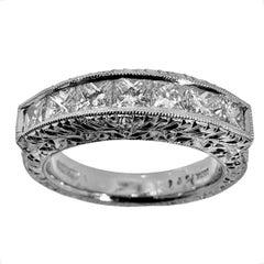 Bracelet en platine gravé avec sept diamants de taille Princesse sur le dessus.
