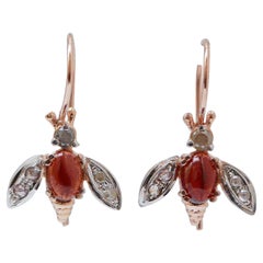 Pendientes en forma de mosca de granates, diamantes, oro rosa y plata.