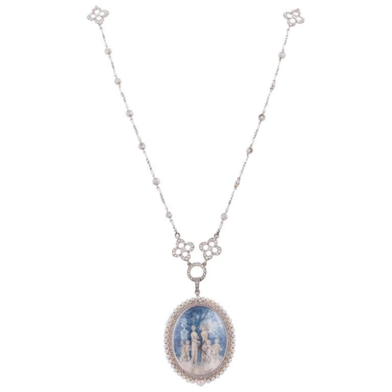Exquisite platinum, diamond and pearl Paillet pendant watch. The dial is composed of painted blue, cream and white designed as a Grecian garden scene with two women, three children and a dog. The back of the watch is clear glass displaying a T