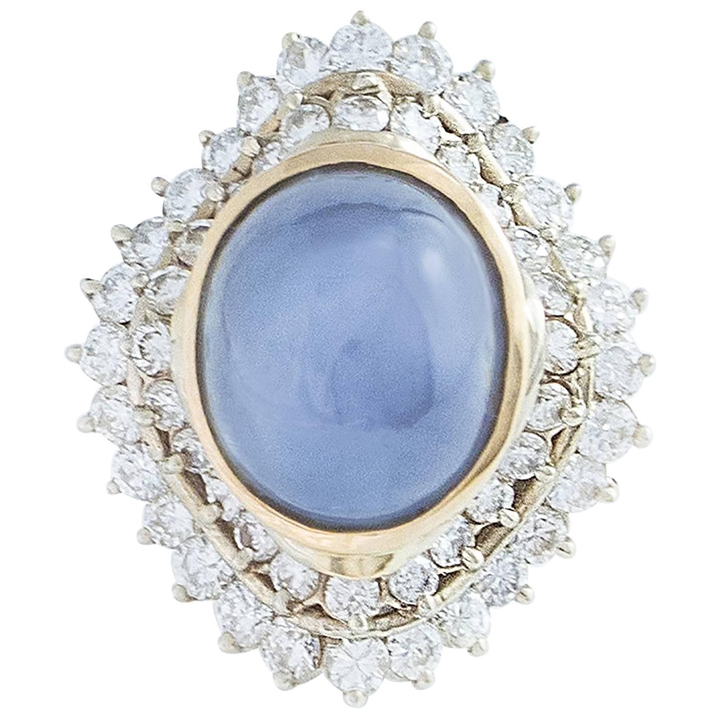 A natural Blue Star Sapphire weighing 14.50 carats is surrounded by 2 rows of G-H full cut White Diamonds totalling 1.90 carats in this elegant Ballerina style 18K White and Yellow Gold ring.  

Large and impressive, the head measures 26mm north