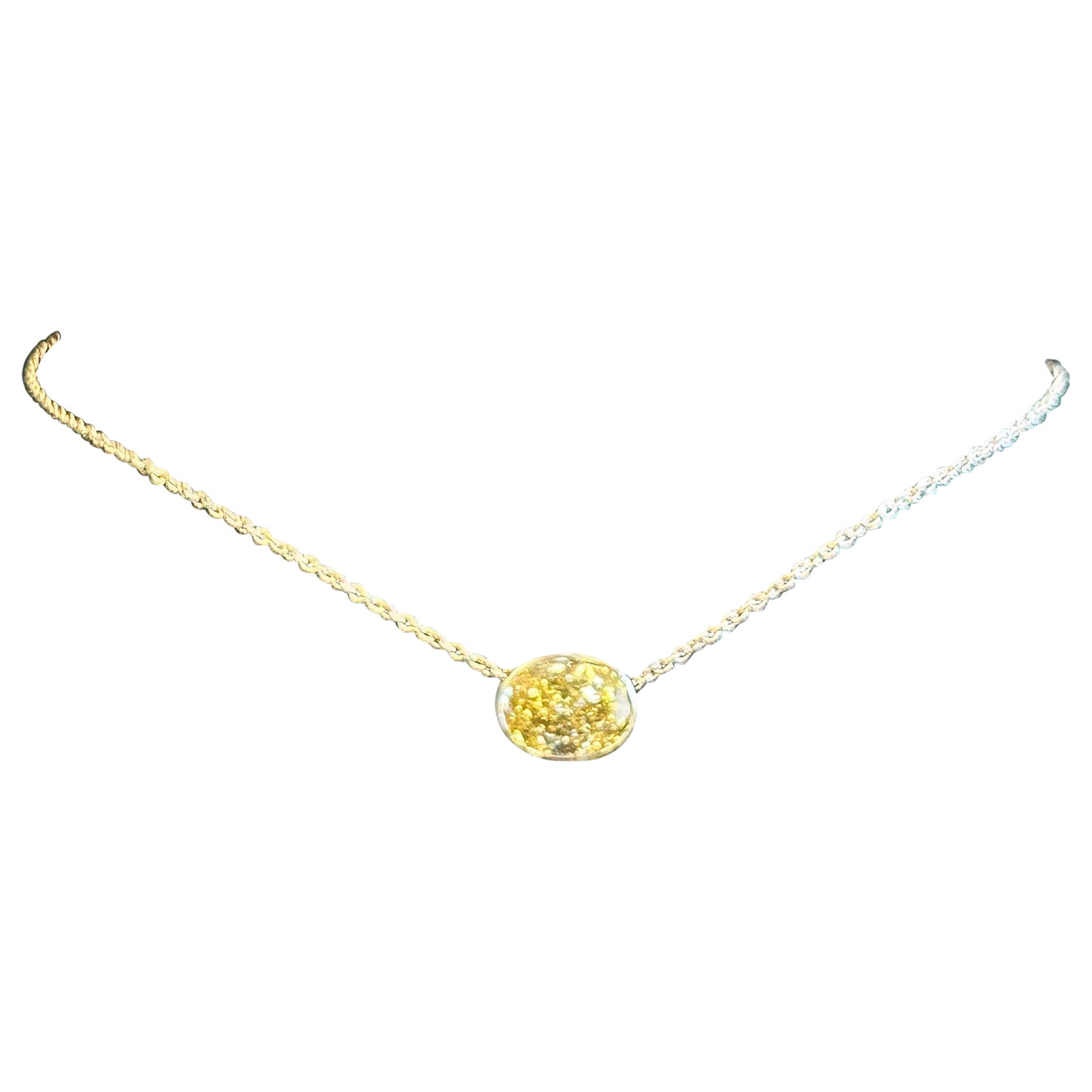 Questa splendida collana con ciondolo è caratterizzata da un'affascinante pietra color giallo-marrone incastonata in una montatura che sembra essere in stile castone. La pietra di platino da 5,82 carati è un diamante ovale di colore giallo