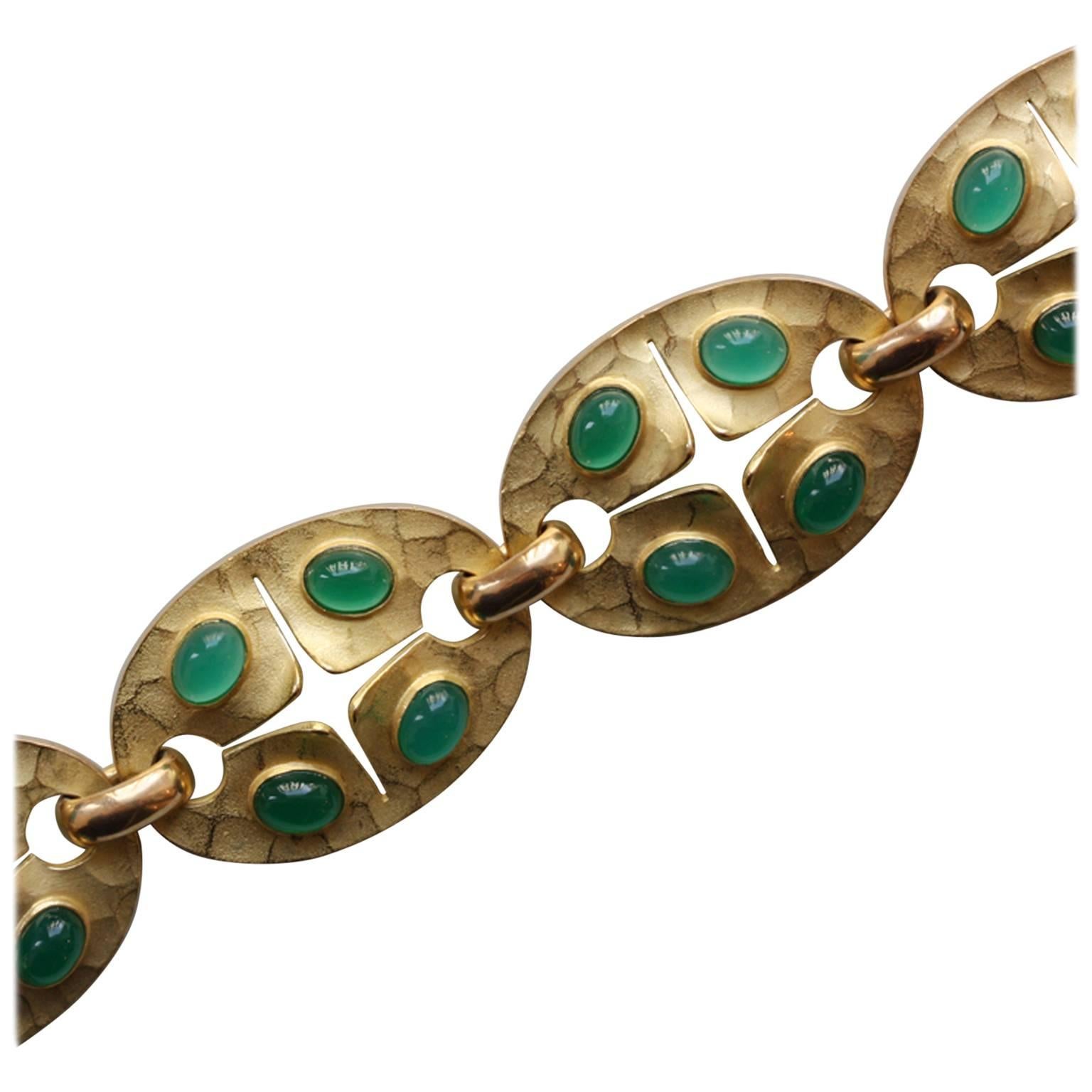 A 18 carat gold and chrysoprase bracelet composed of 6 oval hammered links each set with 4 cabochon cut chrysoprases, Georges Lenfant, circa 1970.

weight: 47.5 grams
dimensions: 20 x 2.3 cm