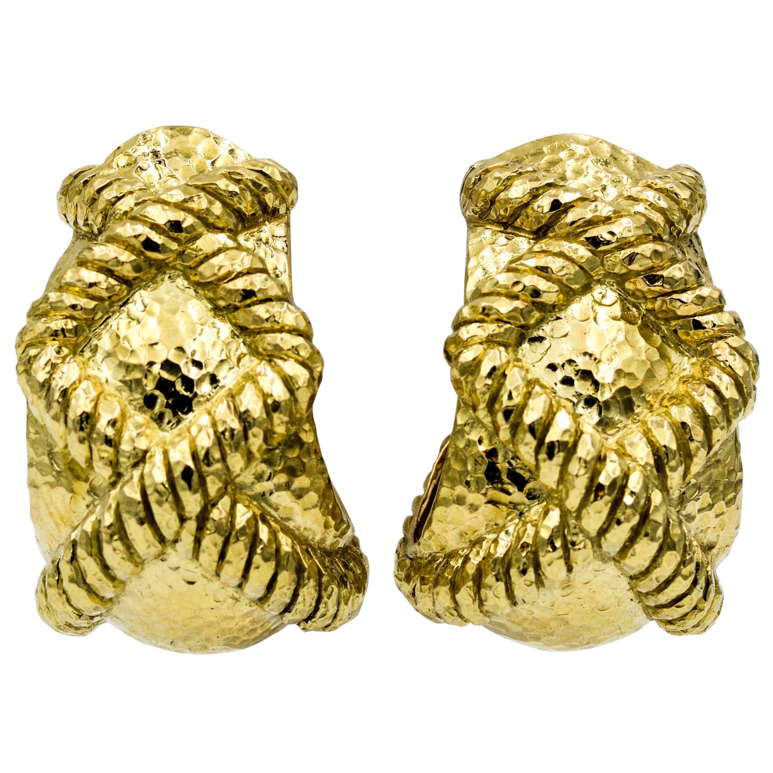 Driven by art, design and bold pieces these earrings embody David Webb’s textured gold statements. These clipped back 18K yellow gold earrings have two banded X's set in a hammered finish. The earrings measure 35.25 mm tall and 22.55 mm wide, and