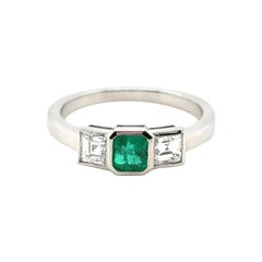 Anello di fidanzamento in platino a tre pietre con smeraldo e diamante da 0.40 carati