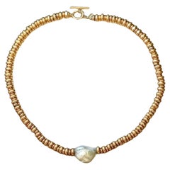 Collana in oro giallo e argento ornata di una perla grezza