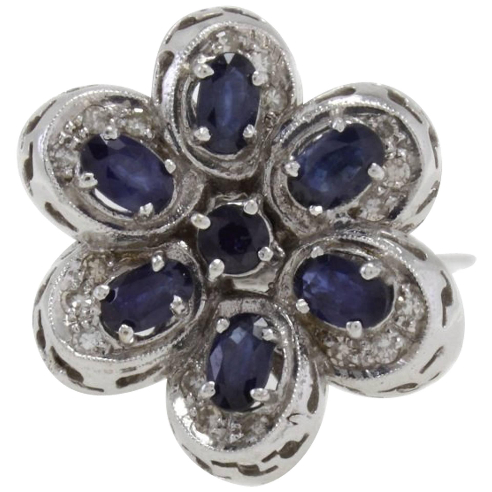 Flower shaped  fashion ring in 18k white gold mounted with white diamonds and blue sapphires.
Diamonds 0.32 kt
Blue Sapphires 2.55 kt
Tot.Weight 11.40 gr
R.F ggfc