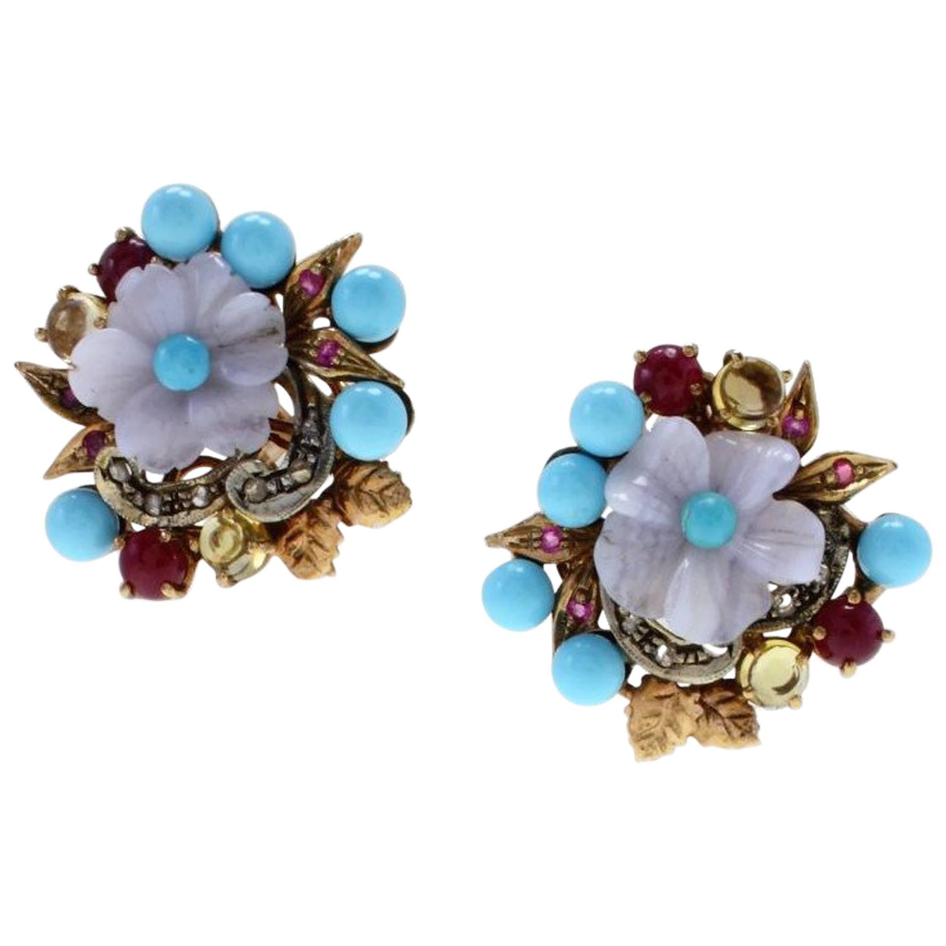 Classic and elegant earrings in 9Kt gold and silver, with a flower shaped stone  adorned with turquoise, rubies and yellow topaz and diamonds.
turquoise (1.83gr) 
topaz(2.42Kt)
diamonds(0.15Kt) Tot weight 10.3gr
ref  79803