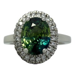 Bague halo en platine, saphir bleu vert et diamant bicolore taille ovale de 1.93 carat