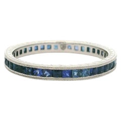 Anello a fascia per l'eternità in platino con zaffiro blu taglio francese inciso sui lati con lavorazione a grano