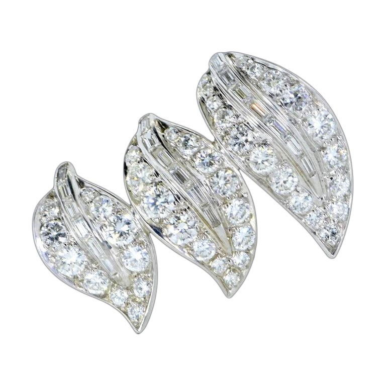 Barrette vintage en platine, 15K et diamants fins à motif de feuilles, C.C. 1950. 19 diamants baguettes droits sont sertis en canal au centre et entourés de 43 diamants ronds, sertis en perle. Le poids des 62 diamants est estimé à 1,75 ct. Ces