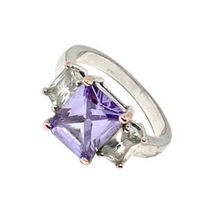 Zircon cubique central de couleur violet lavande taillé en princesse, deux baguettes transparentes en accent