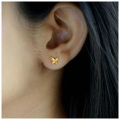 Pendientes minimalistas de oro amarillo de 14 quilates con forma de mariposa.