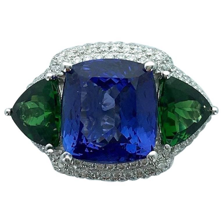 Top color matching! 
This 5.69 carats Tanzanite is surrounded by diamond pave with two Tourmaline triangle cut weighting 1.94 carats total. The mounting is in white gold 18k 750.
Contemporary.

Gross weight: 8.44 grams.