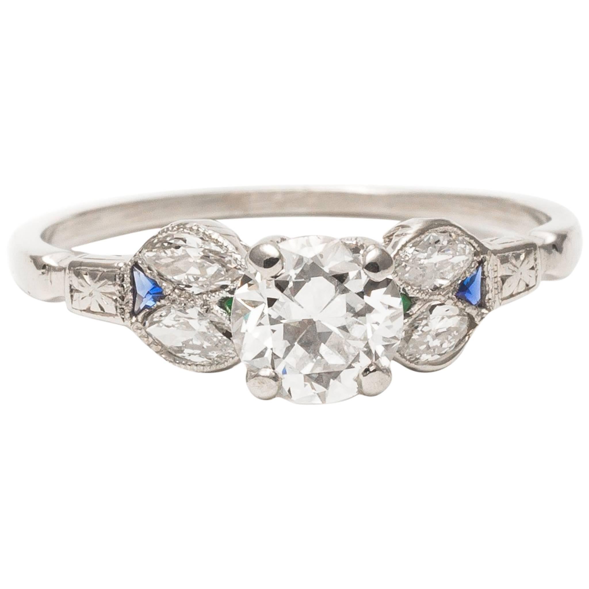 A beautiful original art deco period diamond engagement ring in platinum.  Centered by a high quality antique European cut diamond this ring features a pair of trillion cut sapphires and emeralds along with accenting marquise shaped diamonds.

Of
