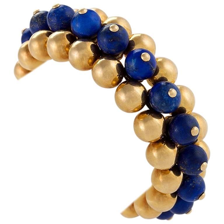 This 1930s lapis lazuli bead bracelet by Marzo Paris is a miniature Art Moderne study of geometry and volume. The bracelet is both sculptural and playful, drawing the eye with its contrast of two rows of gold beads surrounding a central row of royal