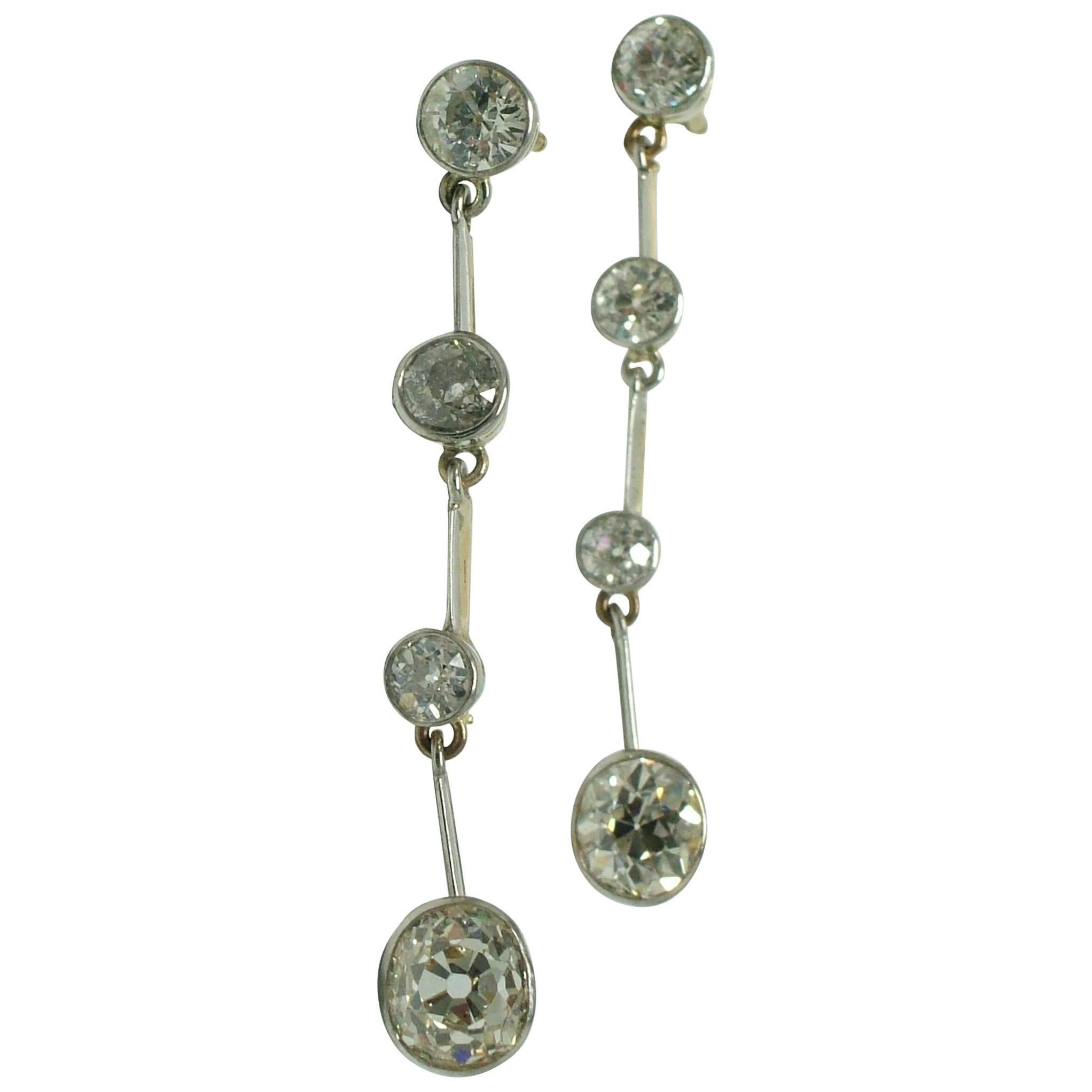 Antique diamond pendant earrings crafted in platinum over gold, featuring four pairs of bright antique old cut diamonds.