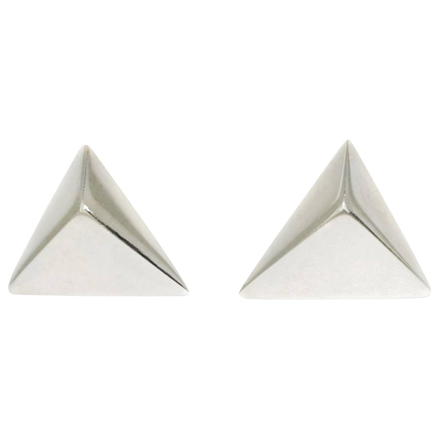 These minimalist, geometric stud earrings are versatile and can be worn both with business attire and more casual outfits. The pyramids' peaks are positioned off-centre, creating an interesting play of light and reflection on the highly polished