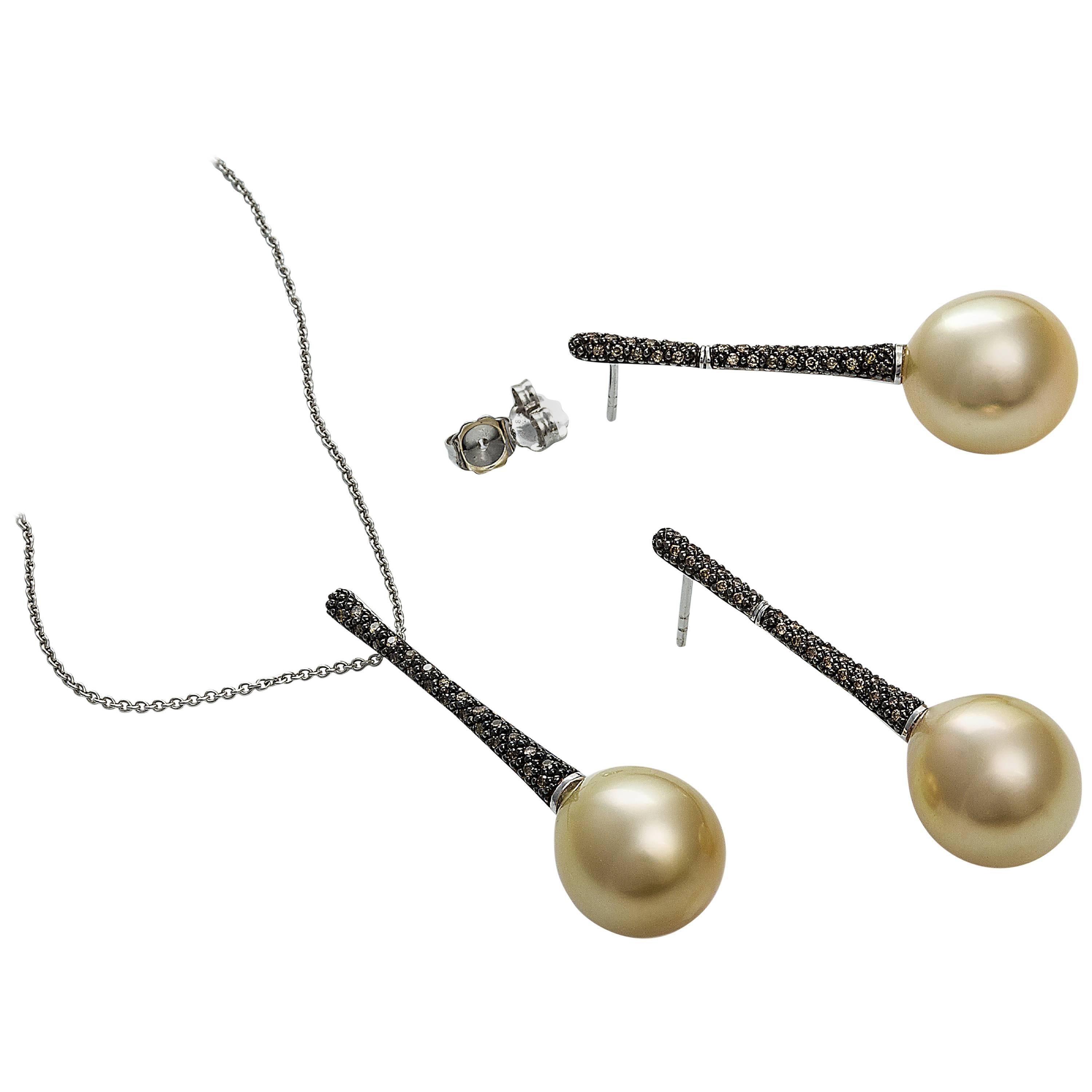Beautiful collection of long drop diamond and golden South Sea pearl pendant and earrings.

This exclusive set is made of 18 carat white gold with a featured front panel with a black rhodium finish which is set with 0.55 carat cognac diamonds.

The