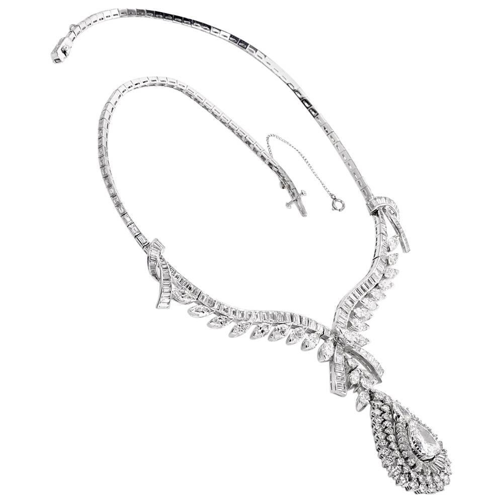 This conspicuous diamond necklace with a detachable pendant is crafted in solid platinum. Depicting romantically designed ribbon 'knots' on both sides, and diamond-studded ribbon ends at the center, this versatile necklace can be worn with or