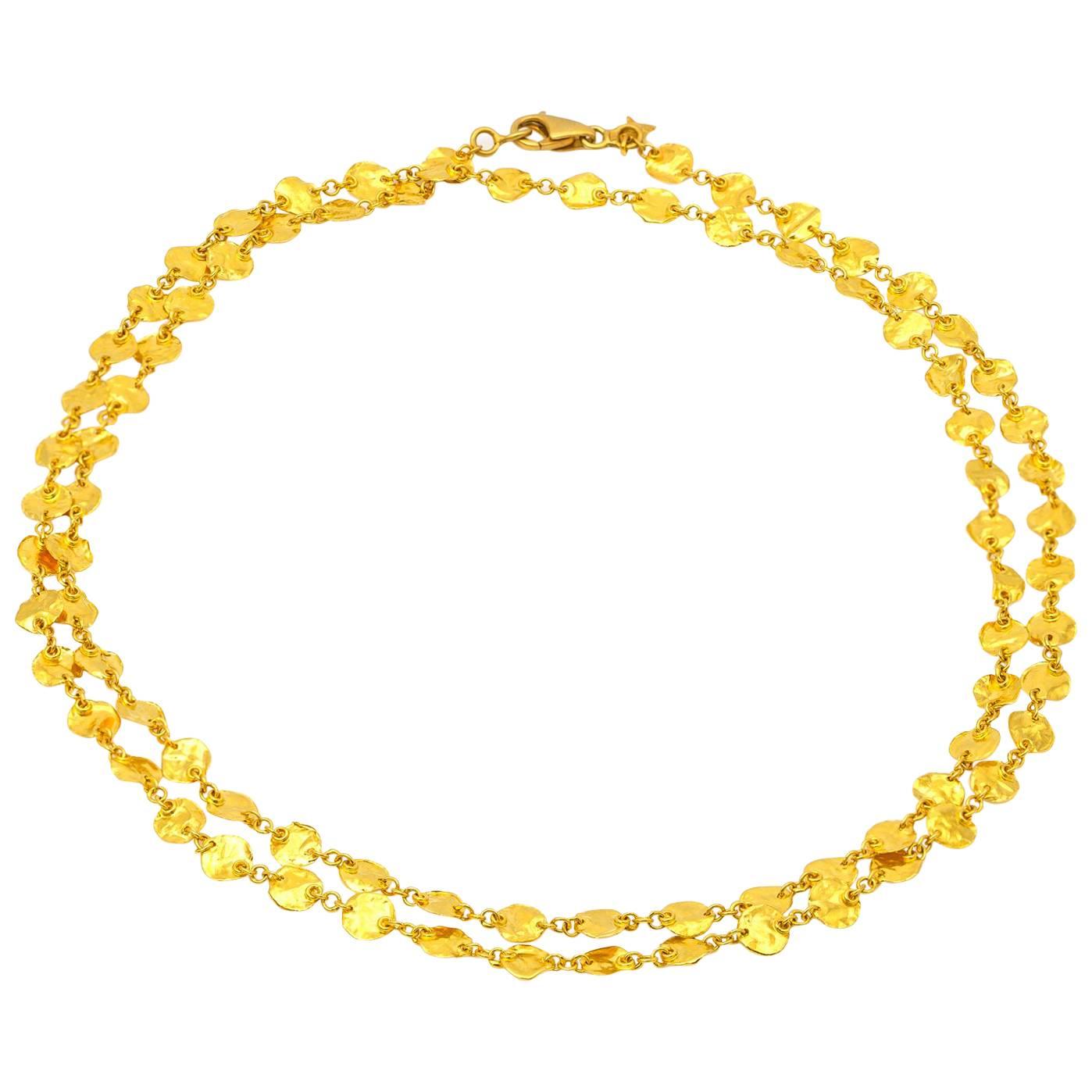 Rich, bright yellow gold hammered coins easily worn in a single strand or doubled up. The reflective quality of the gold sings in the brightest of yellow and the delicacy of the coins in amplified by the incredible 31 inches of length. 24ct yellow
