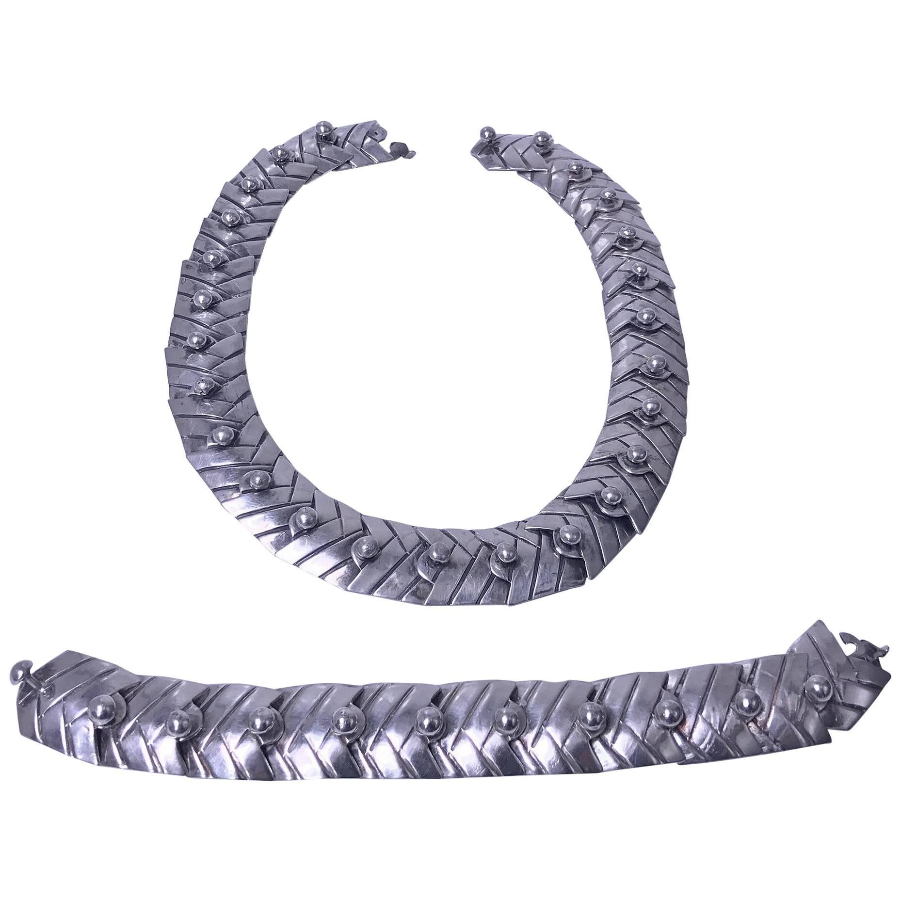 Collar y pulsera a juego de gran chevrón flexible y esfera de plata, posiblemente sudamericanos C.1950. Los eslabones son de diseño acanalado, cada uno acentuado y conectado con media cuenta de plata en el poste que termina con un poste de cuentas
